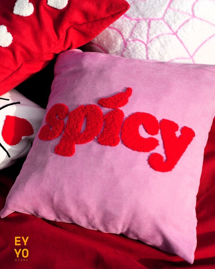 Pink pillow with red 'spicy' text on a red background, Spicy energy text tufted cotton cushion cover on pink fabric